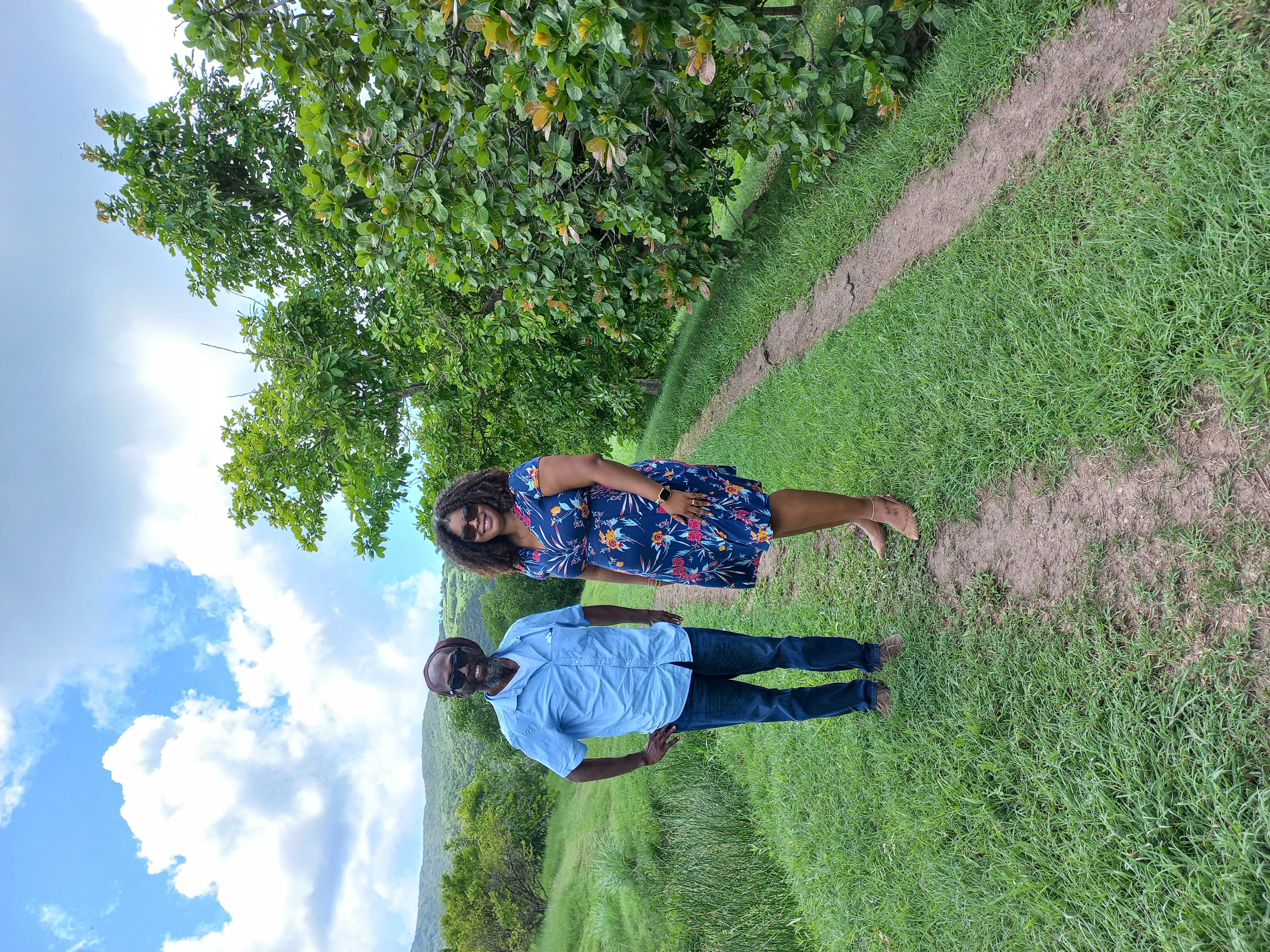 From left to right are Mr. Gregory Bailey, Director of Agriculture, and Mrs. Andrew on a farm following his recording.