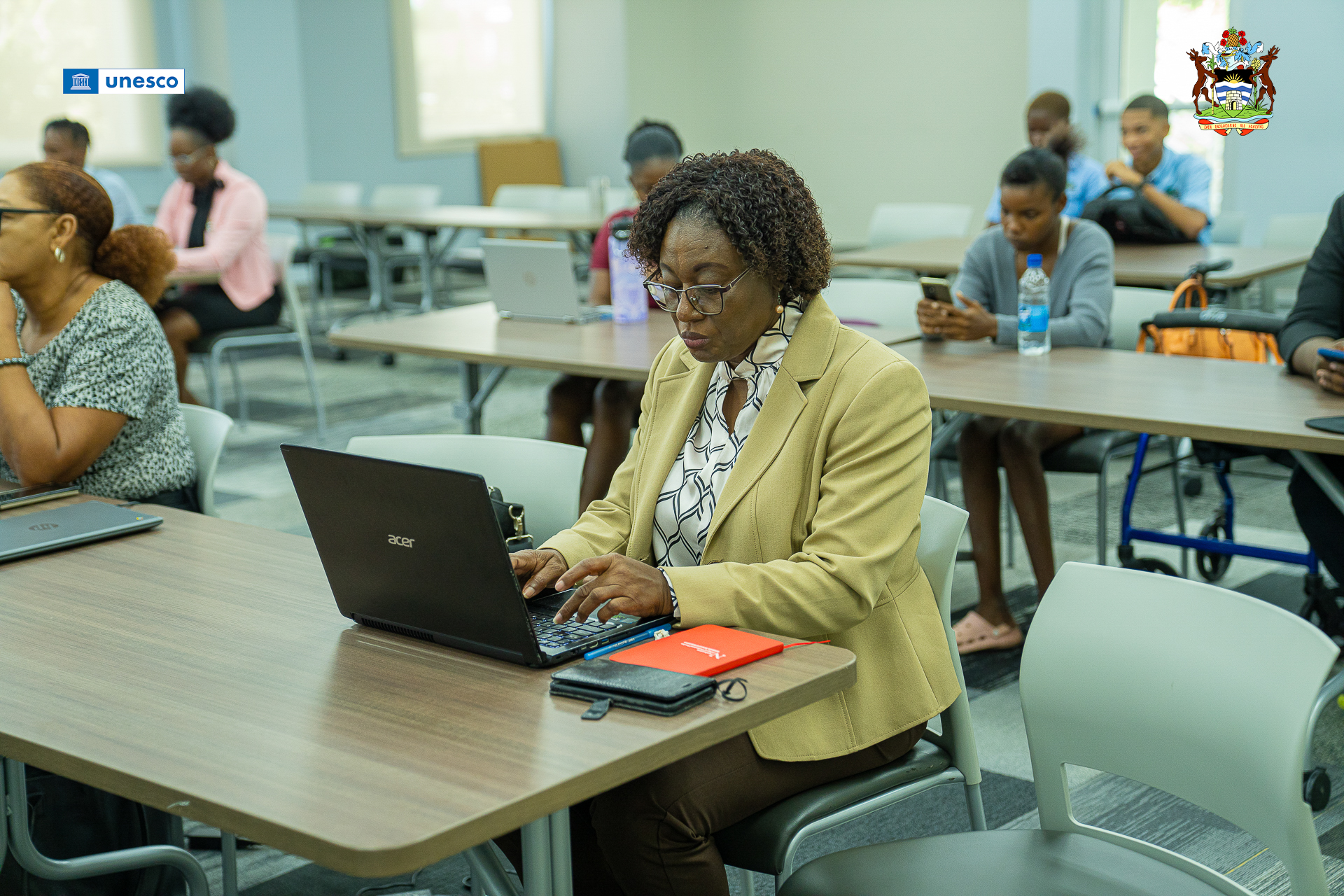 Mrs. Shelly Galloway, Education Officer within the Ministry of Education sits with an open black laptop.